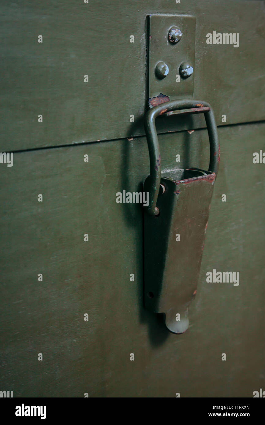A green military storage box for ammunition. Green box from the war with scratches and locks in