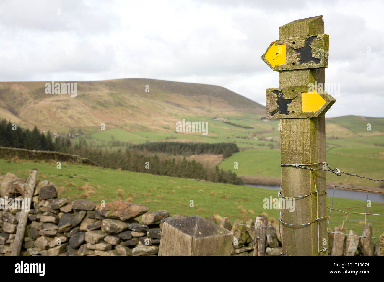 Footpath signs with Pendle Hill in the background above the village of Barley, in the Borough of Pendle Lancashire. The area is popular with walkers a Stock Photo