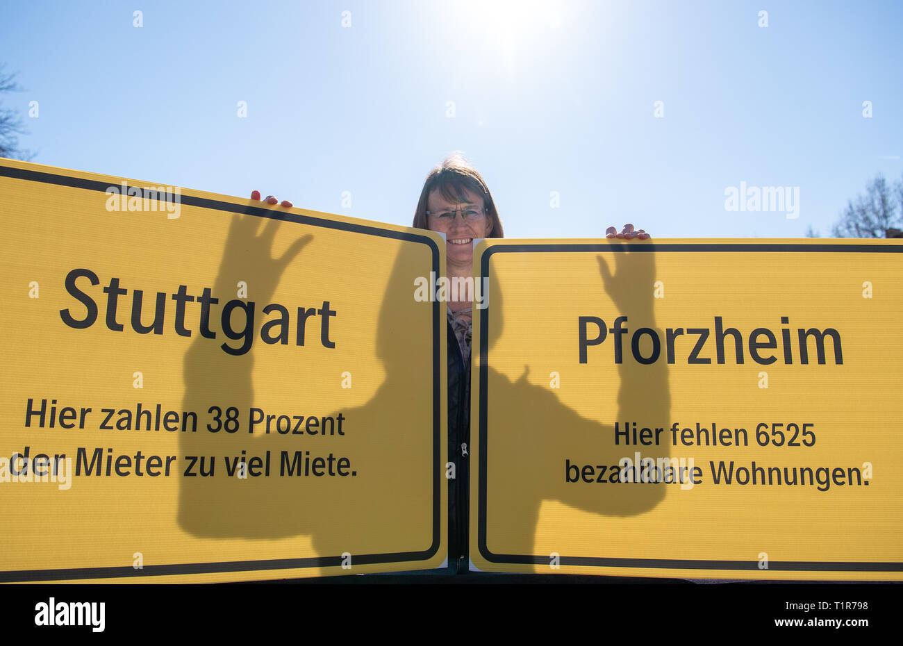 28 March 2019, Baden-Wuerttemberg, Stuttgart: A participant of the action of the German Federation of Trade Unions (DGB) holds two signs with the inscription 'Pforzheim - Here 6525 affordable flats are missing' and 'Stuttgart - Here 38 percent of the tenants pay too much rent'. The campaign aims to draw attention to the problem of rising rents, a lack of social housing and a lack of inexpensive building land. Photo: Fabian Sommer/dpa Stock Photo