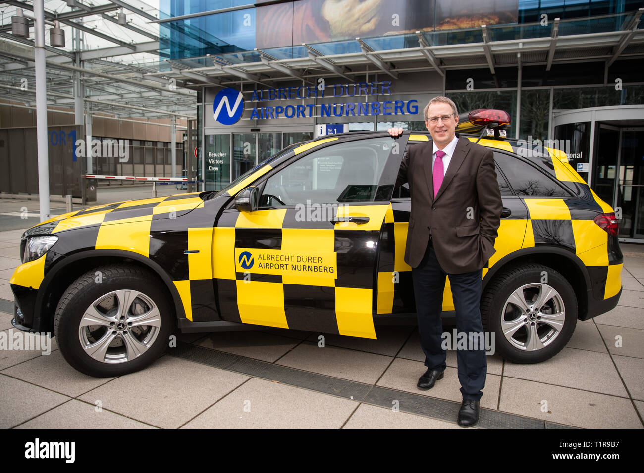 28 March 2019, Bavaria, Nürnberg: Michael Hupe, Managing Director of the Albrecht Dürer Airport Nuremberg, stands at the edge of the annual-Pk at a 'Follow me' vehicle. Photo: Daniel Karmann/dpa Stock Photo