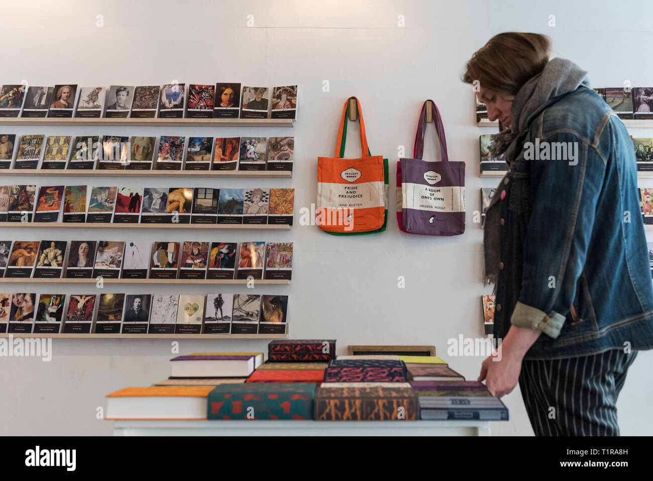London, UK. 28 March 2019. A visitor browses at the Penguin Classics pop-up  shop near Brick Lane in East London. Every single Penguin Classic title  (over 1,200 books) is on display celebrating