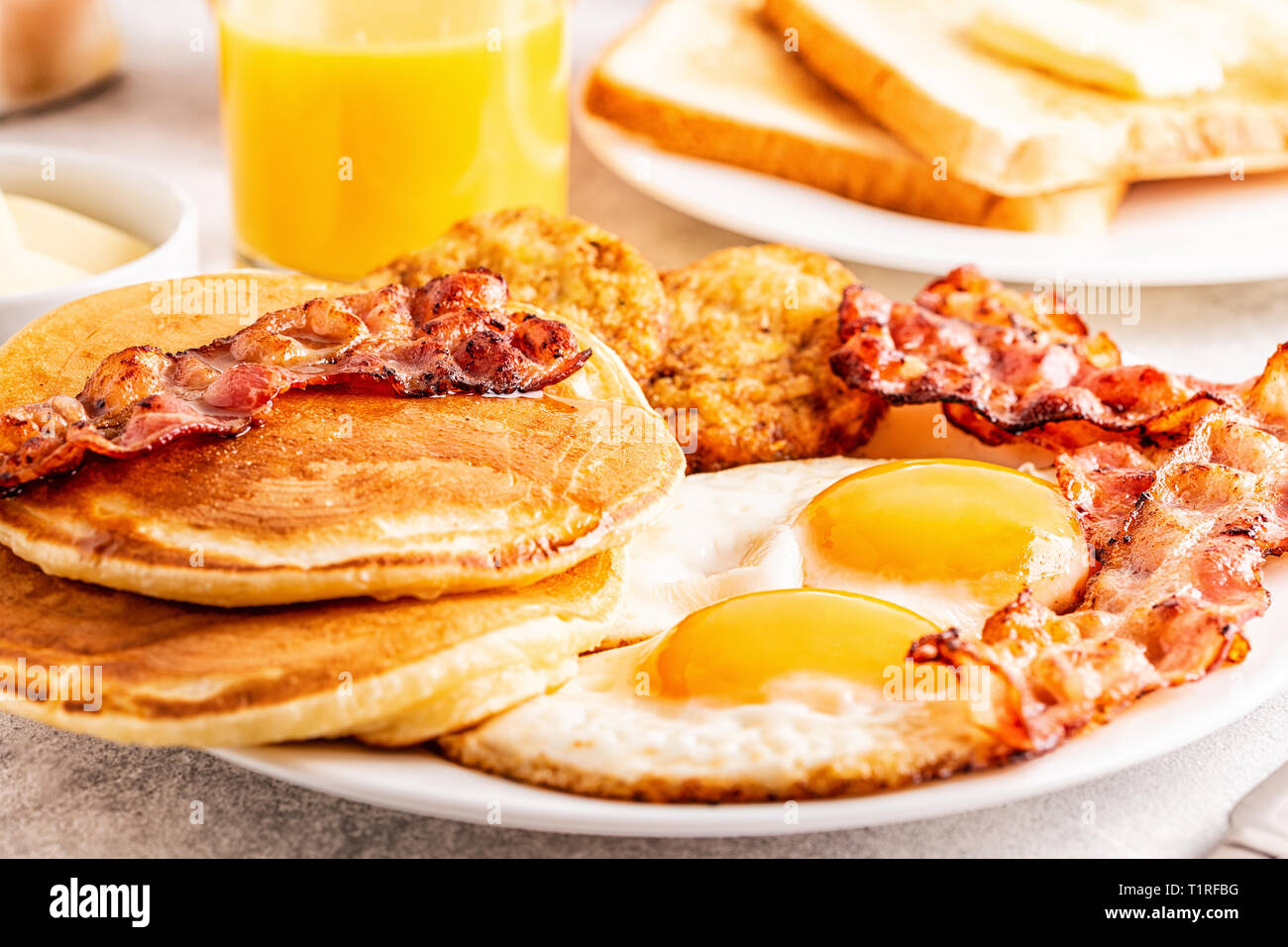 Healthy Full American Breakfast with Eggs Bacon Pancakes and Latkes, selective focus. Stock Photo