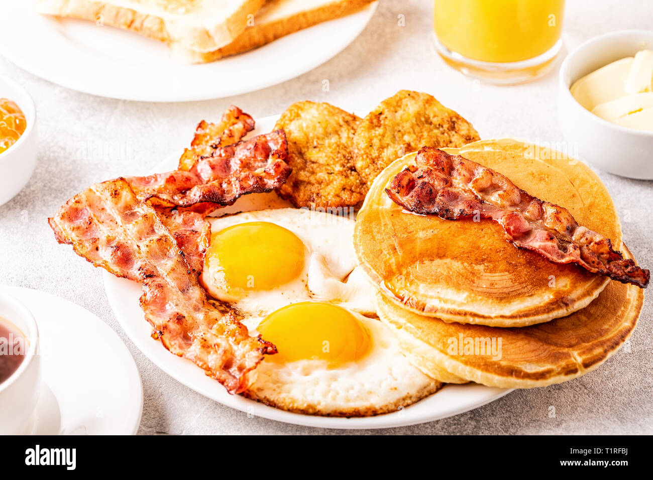 Healthy Full American Breakfast with Eggs Bacon Pancakes and Latkes, selective focus. Stock Photo