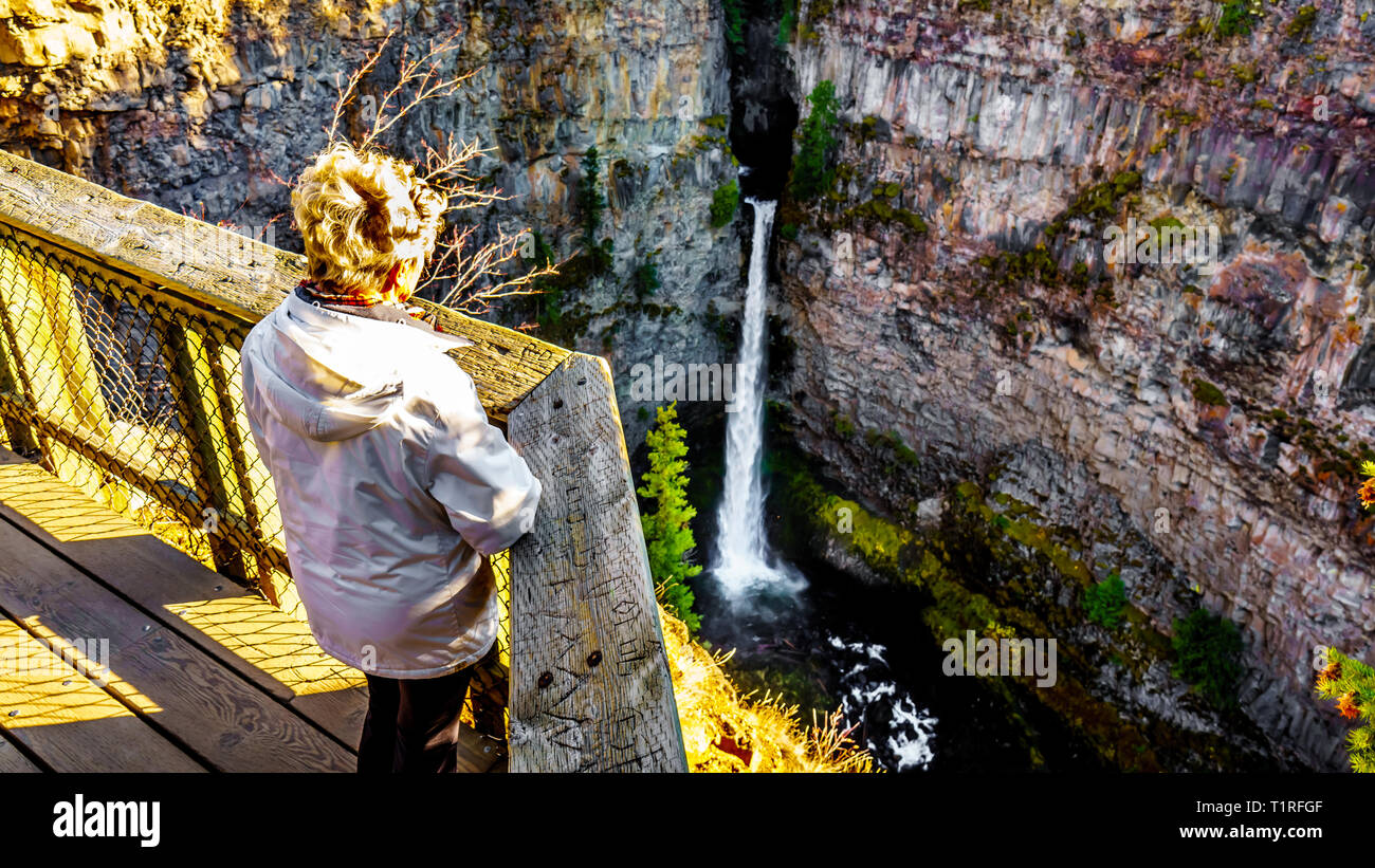 Senior woman looking at Spahats Falls on Spahats Creek from the viewing platform in Wells Gray Provincial Park at Clearwater British Columbia, Canada Stock Photo