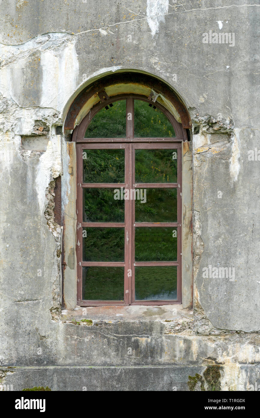 old damaged  plastered brick wall with window. Stock Photo
