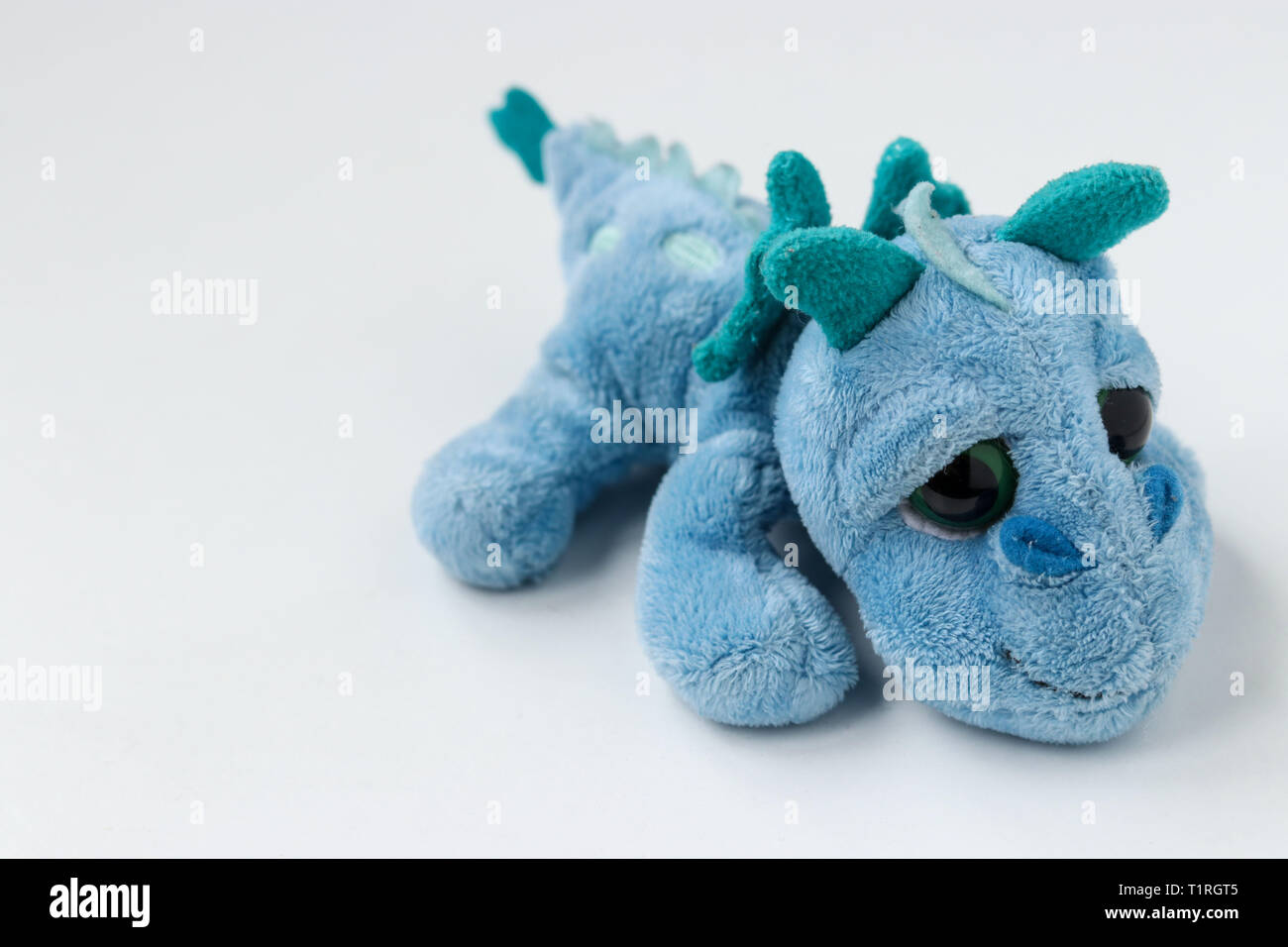 Children's soft toy blue dragon is located on a white background Stock Photo