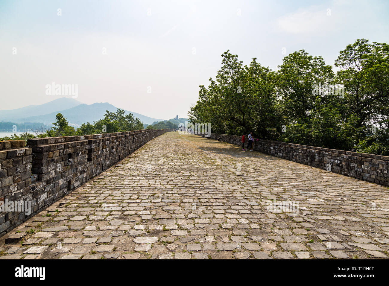 May 2017 - Nanjing, Jiangsu, China - tourists walk on a section of the old Ming Dynasty city walls near Jiming temple. Zijin mountain is visible far a Stock Photo