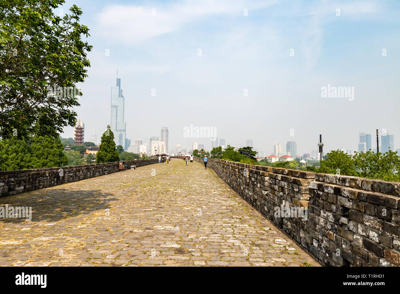 May 2017 - Nanjing, Jiangsu, China - tourists walk on a section of the old Ming Dynasty city walls near Jiming temple. Nanjing skyline is visible in t Stock Photo