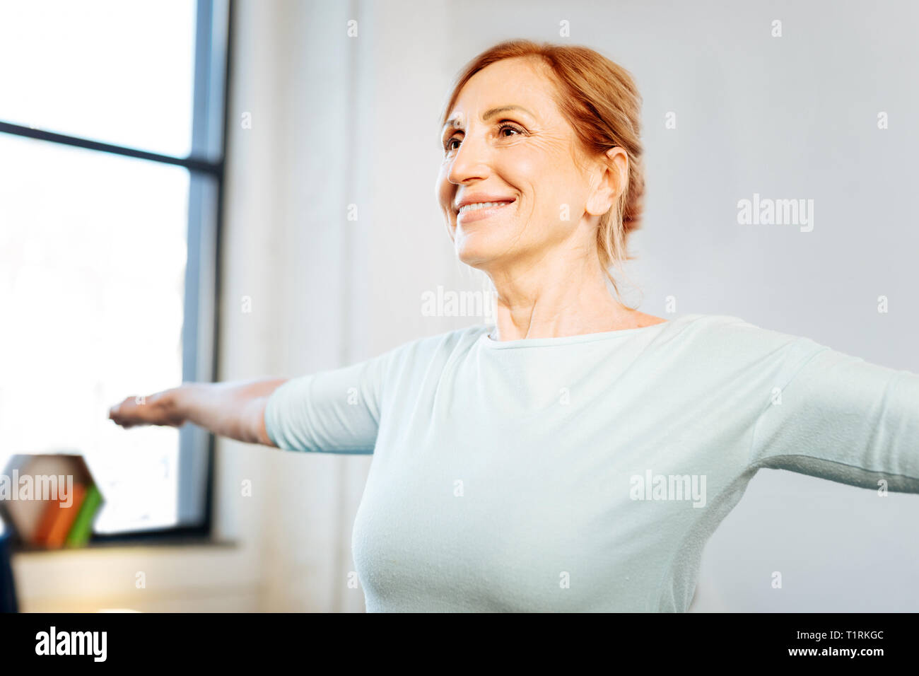 Happy good-looking fit lady with wide smile spreading her hands Stock Photo