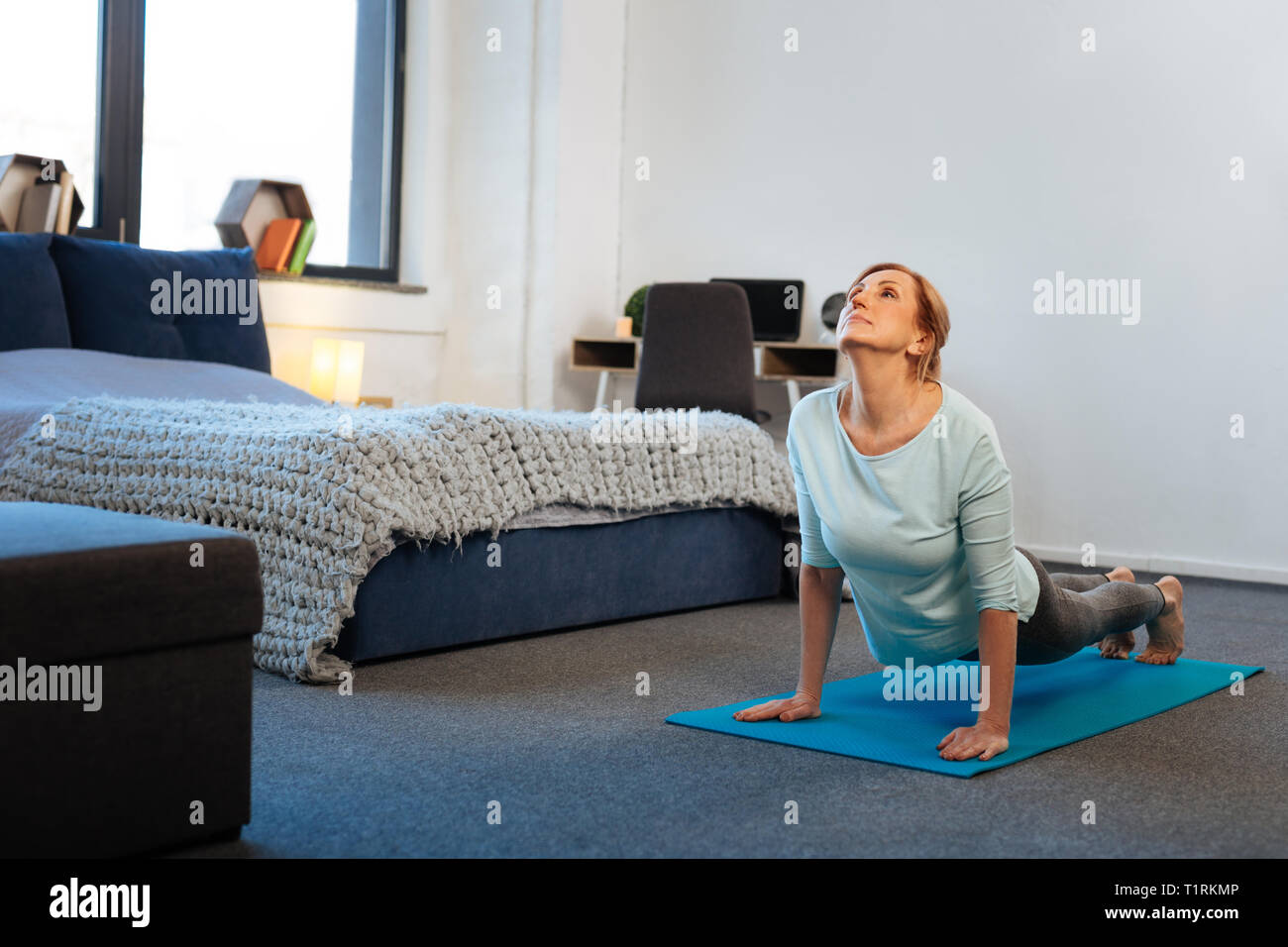 Resolute sportive thin lady standing on her hands while training Stock Photo