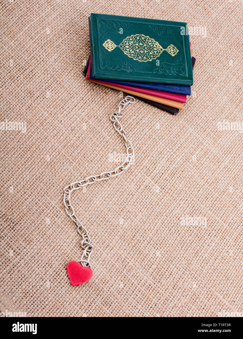 Little sized books attached to a heart with a chain Stock Photo - Alamy