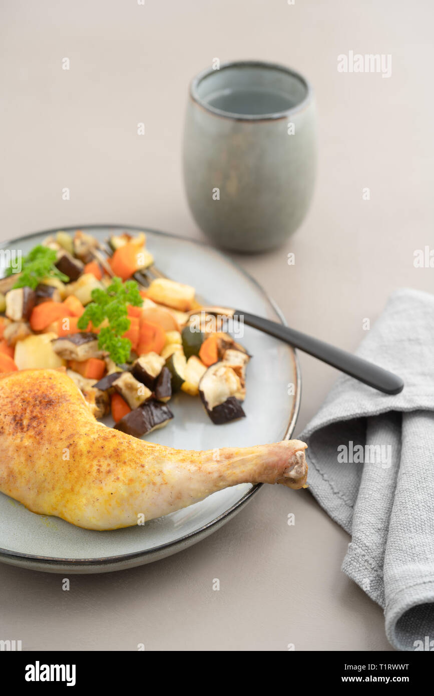 Place setting chicken dinner with oven roasted chicken leg and roasted