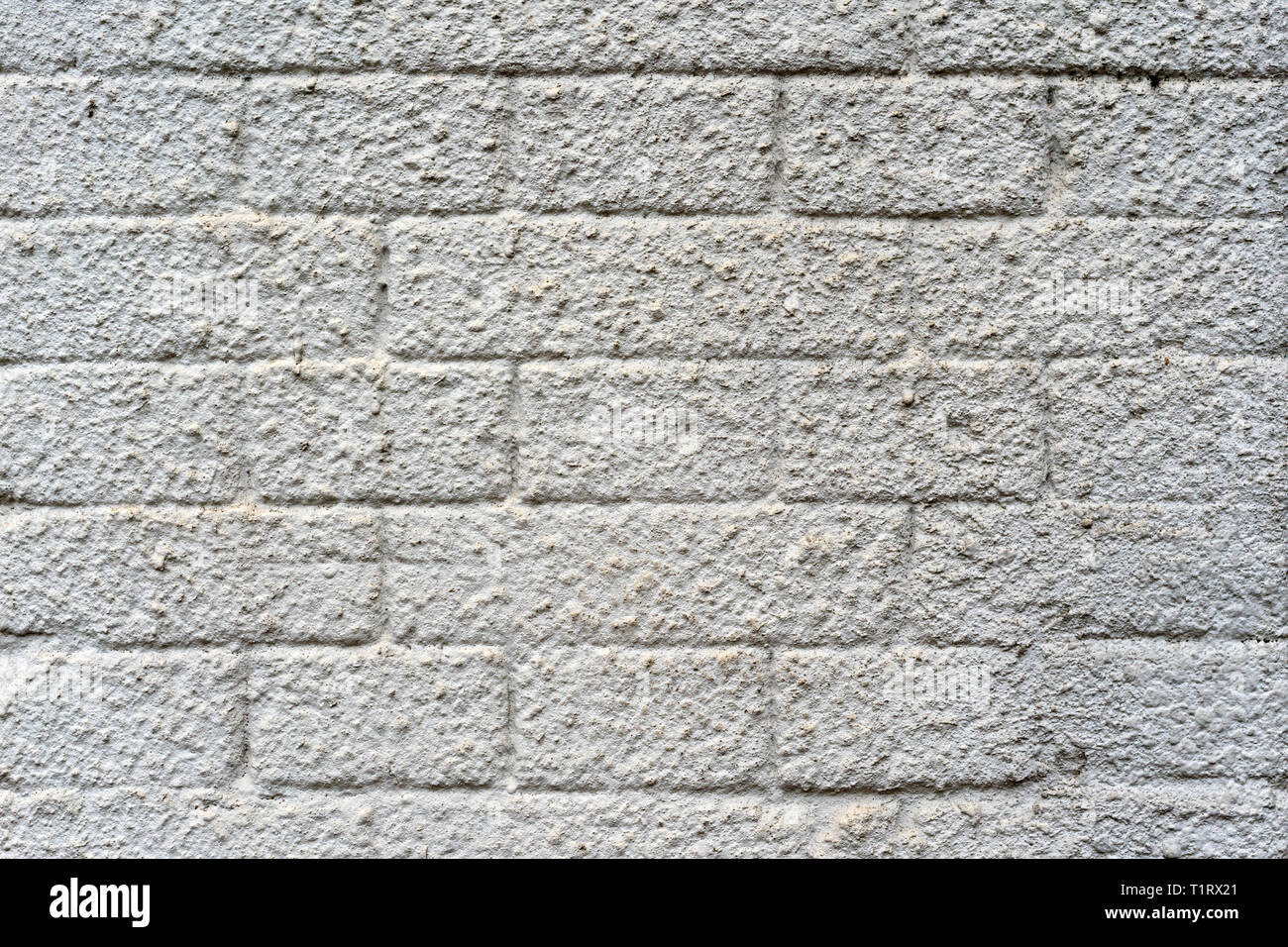 plastered brick wall in yellow and gray Stock Photo