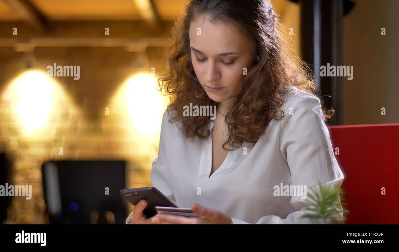 Portrait of young businesswoman doing transactions using credit card ...