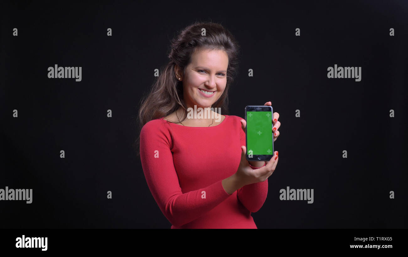 Closeup portrait of attractive middle-aged caucasian using the tablet and showing green screen to camera with background isolated on black Stock Photo