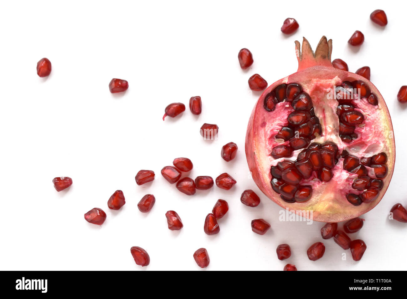 Pomegranate fruit isolated on the white background. Red ripe exotic juicy dessert healthy snack. Whole raw diet organic food. Stock Photo