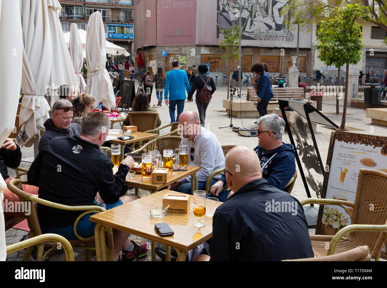Men drinking beer outdoors at a bar, Plaza de la Merced, Malaga, Spain Europe Stock Photo