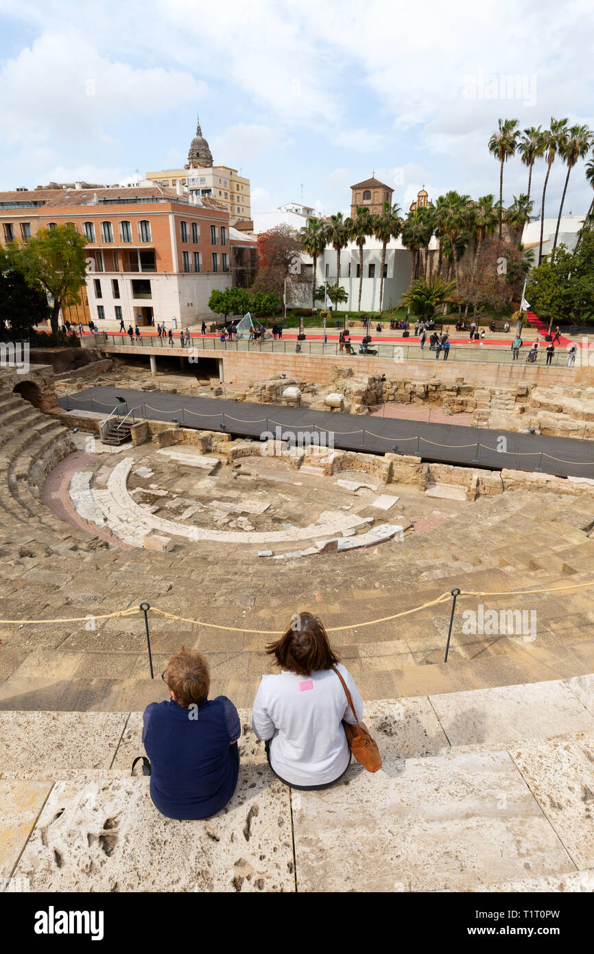 Tourists at the ruins of El Teatro Romano, or Roman Theatre, built in the 1st century BC, Malaga old town, Malaga Spain Stock Photo