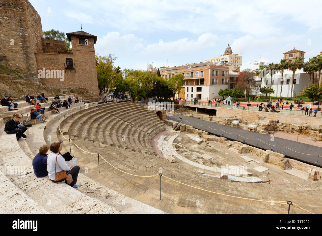 Tourists at the ruins of El Teatro Romano, or Roman Theatre, built in the 1st century BC, Malaga old town, Malaga Spain Stock Photo