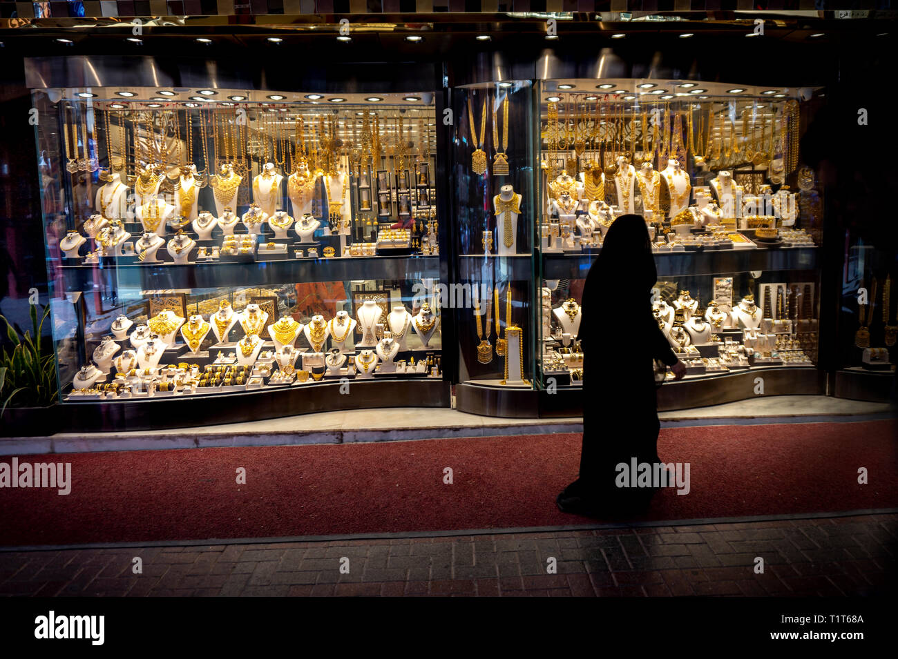 muslim woman in burqa view the windows in the gold souk in Dubai Stock Photo