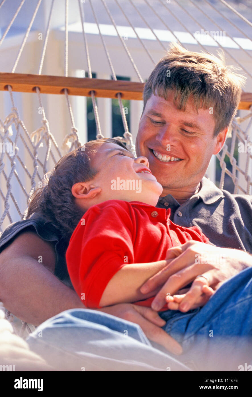Father and son relax in a hammock Stock Photo