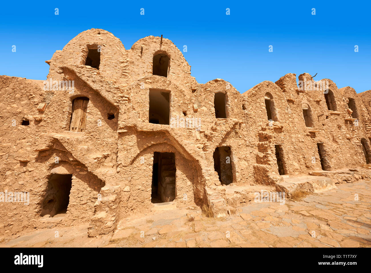 The northern Sahara ghorfa storage graneries of the traditional Berber mud brick fortified Ksar of Hedada or Hadada, near Tetouin, Tunisia, the settin Stock Photo