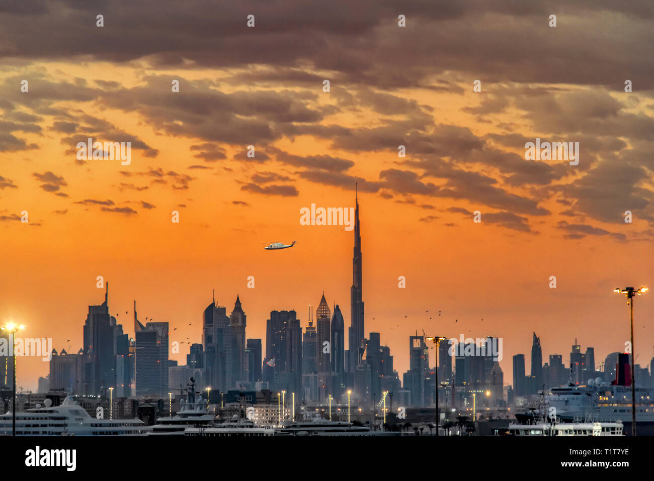 Dubai skyscrapers skyline in sunset orange colors with clouds a