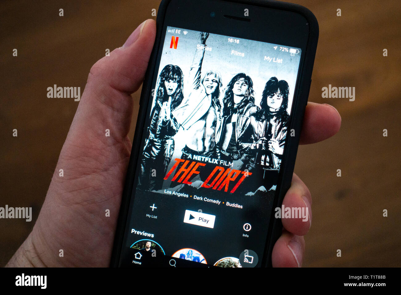 Using a mobile phone to browse Netflix movie streaming app Stock Photo