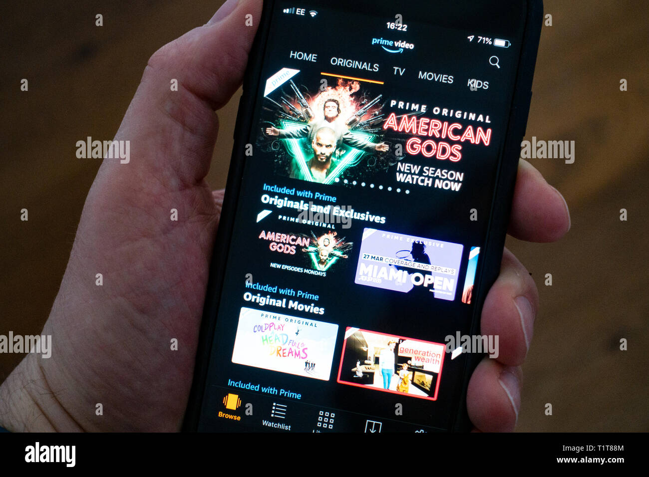 Using a mobile phone to browse Amazon Prime  Video movie streaming app Stock Photo