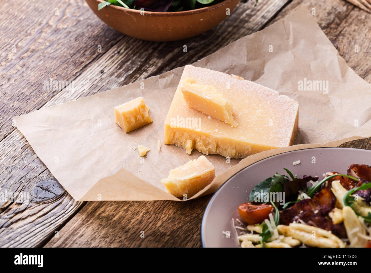 Parmesan cheese on rustic wooden table, traditional Italian cuisine ingredient, close up, selective focus Stock Photo