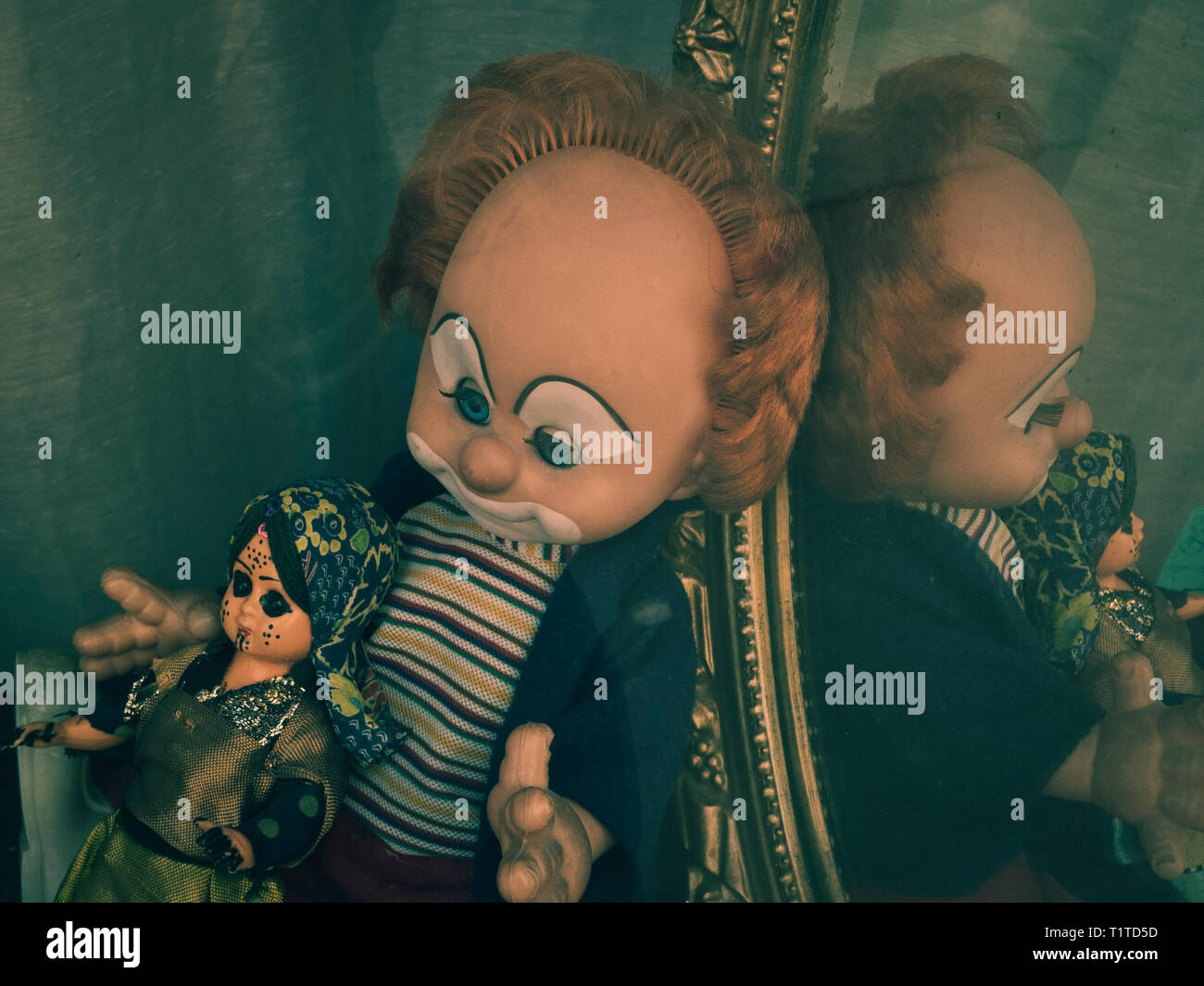 Clown and doll in a bric-a-brac shop window Stock Photo