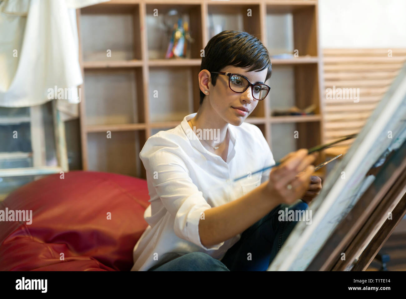 Female artist painting with palette and paintbrush Stock Photo - Alamy
