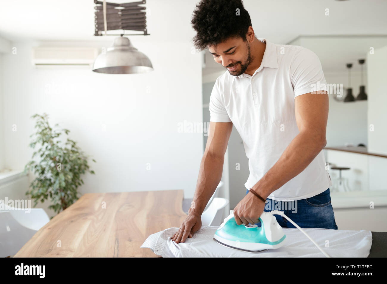Young Happy Man Ironing Clothes Stock Photo