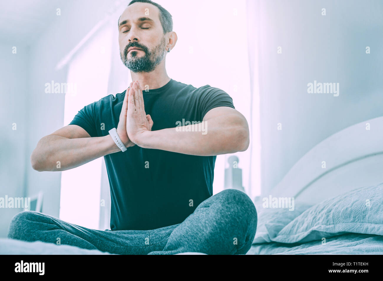 Inspired relaxed man meditating in a light room Stock Photo