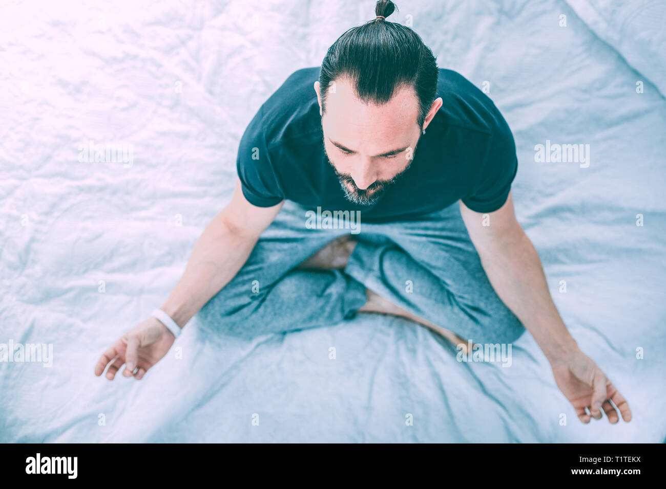 Peaceful relaxed man practicing yoga at home Stock Photo