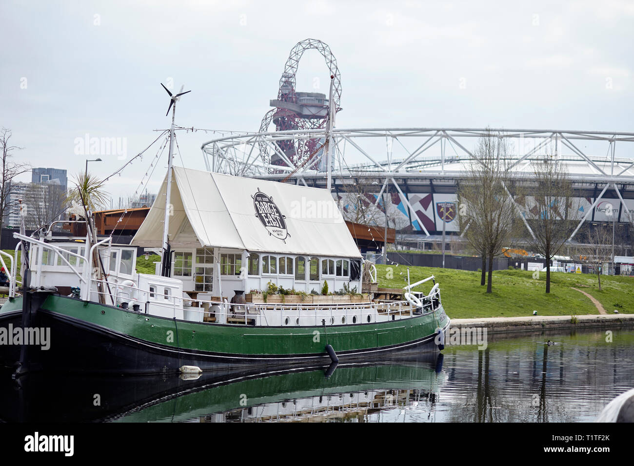 London. Hackney. Barge bar at Hackney wick canal and a view of the Olympic stadium Stock Photo