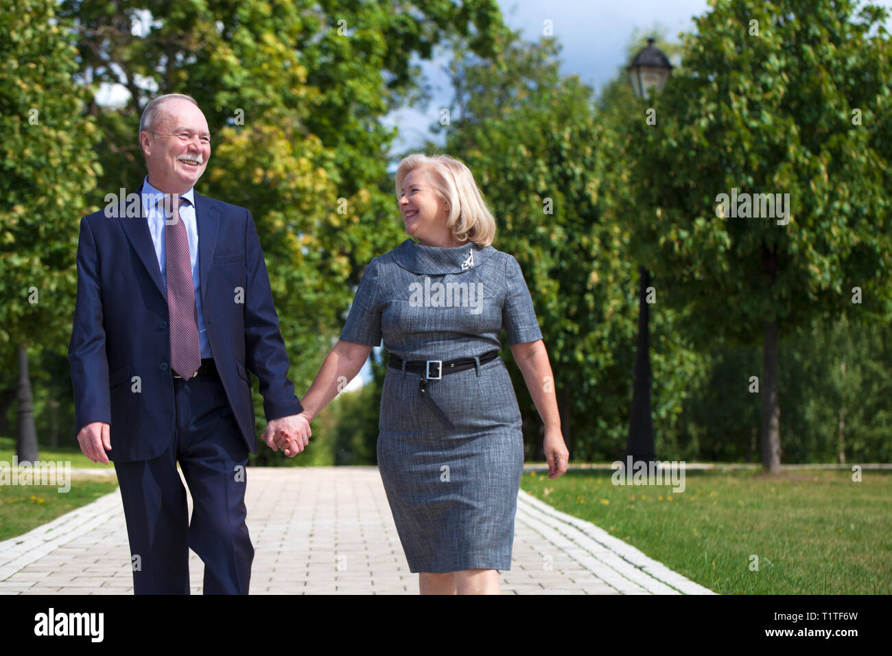 Happy senior couple walking in summer in park Stock Photo - Alamy