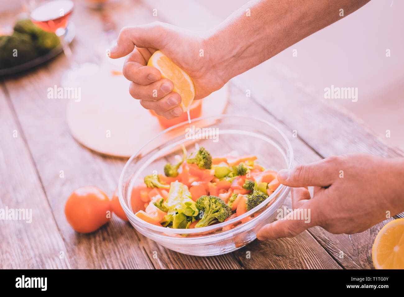 Inspired man adding some lemon juice to a salad stock photo alamy