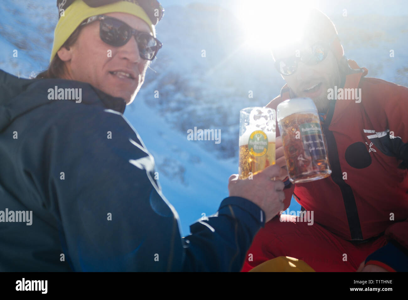 Friends drinking beer and cheering in the mountains Stock Photo