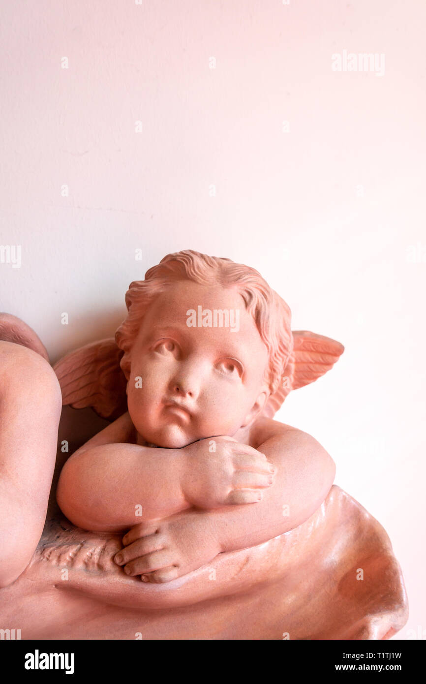 A pretty Cherub leaning on his arms and looking out and leaning on a shell Stock Photo