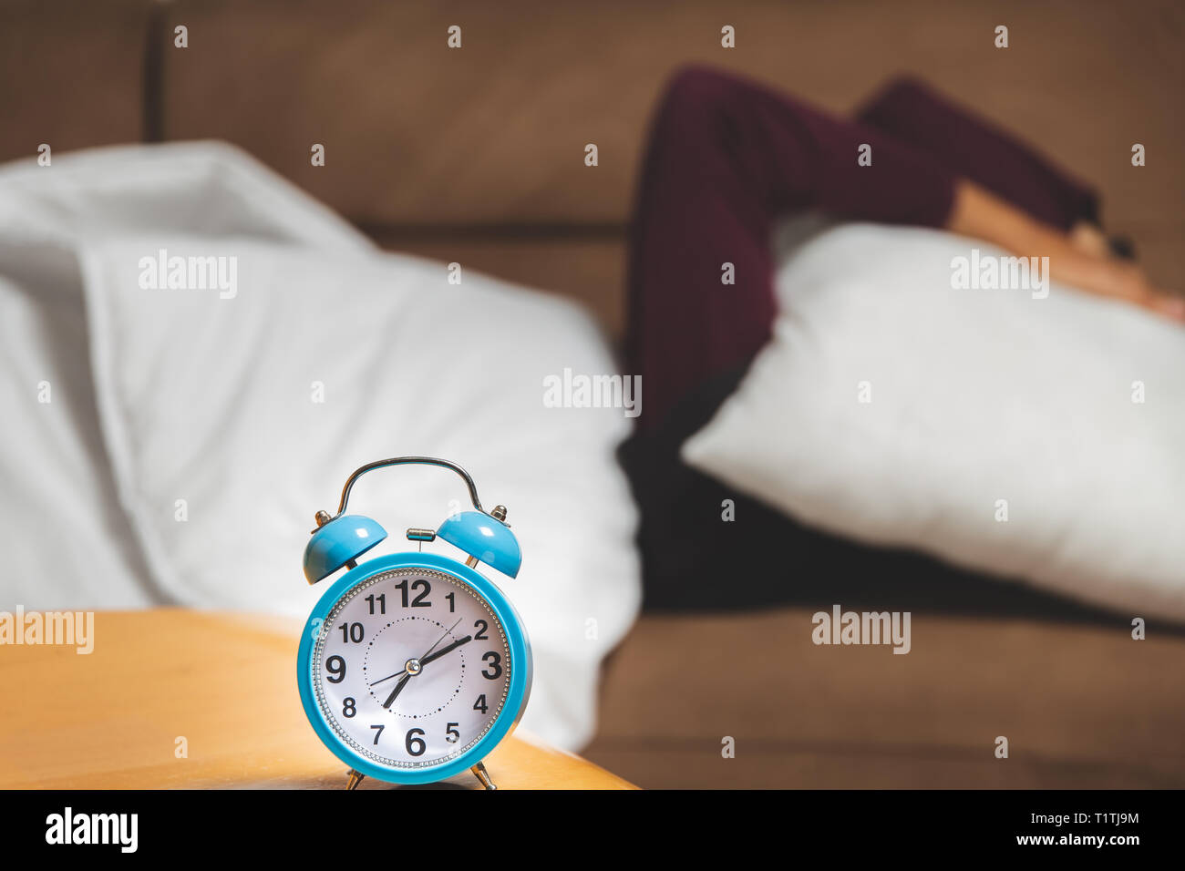 close up view of a guy trying to sleep hiding under a pillow Stock