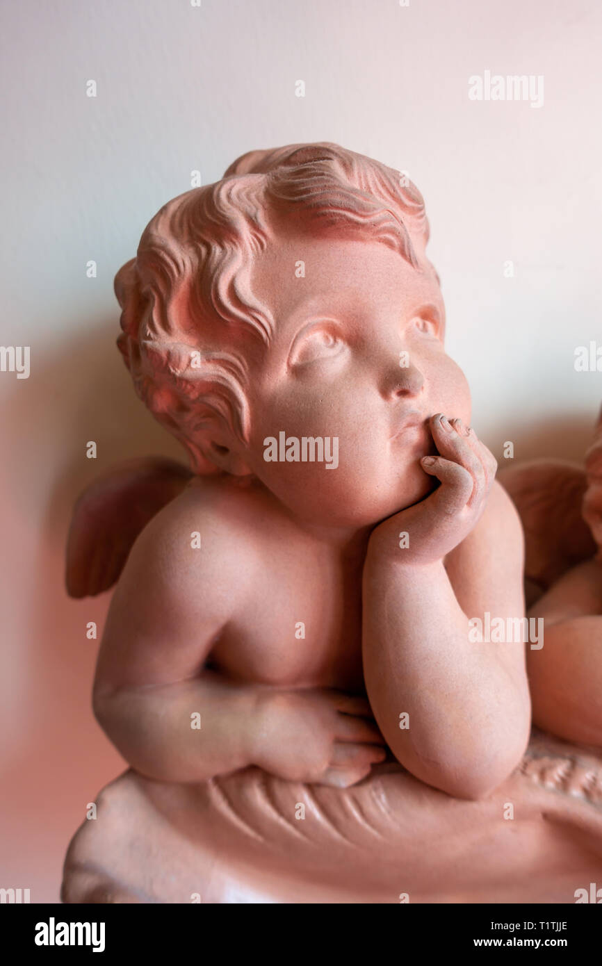 A pretty Cherub leaning on his arms and looking out and leaning on a shell Stock Photo