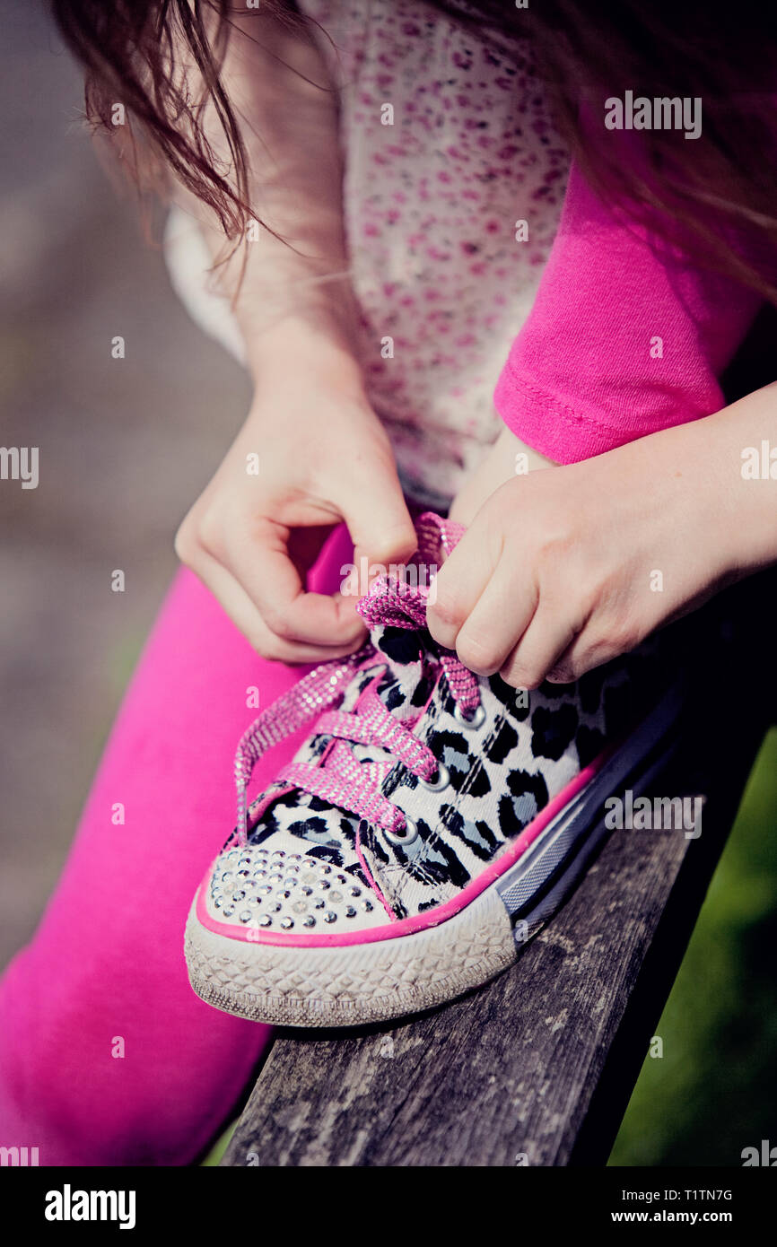 Child fastening shoelaces Stock Photo