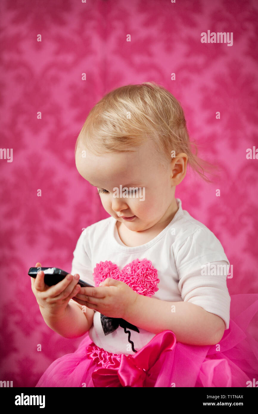 Toddler playing with smartphone Stock Photo