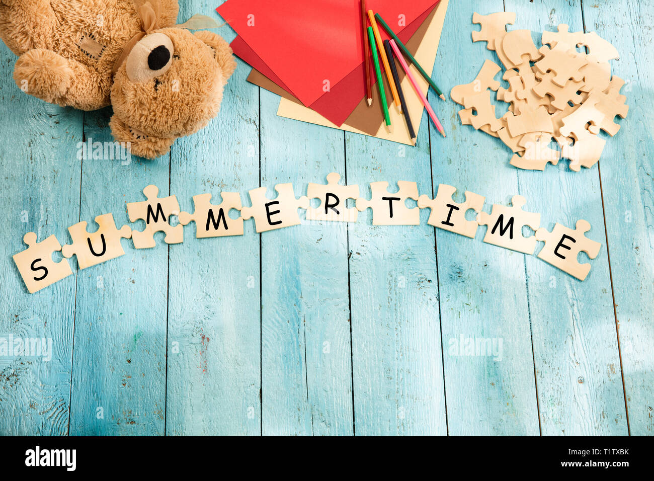 Stationery and words SUMMER TIME made of letters, mock up and pieces of puzzles on wooden background. Travel concept. Summer vacation concepts. Stock Photo