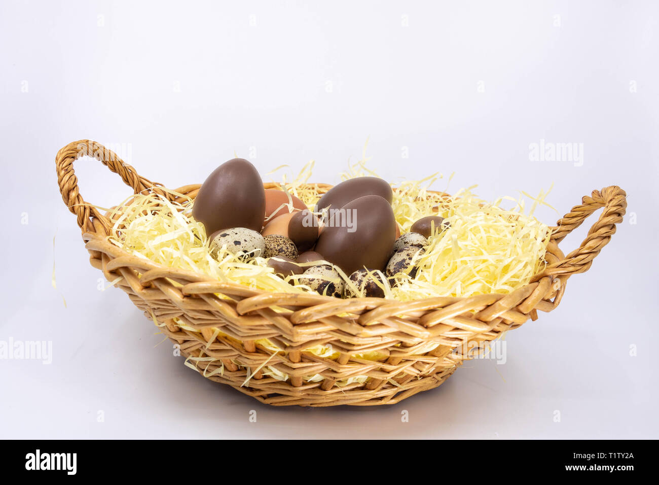 Egg basket for Easter, chicken egg, quail egg and chocolate egg Stock Photo