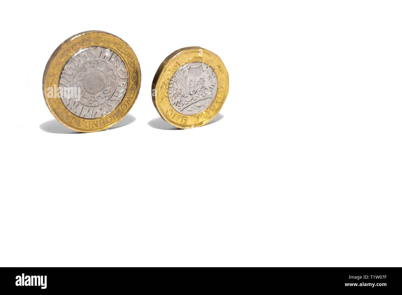 New Great British Pound GBP Coins laying casually on top of black wallet on white background. Wealth, Money, Cash, Change. Stock Photo
