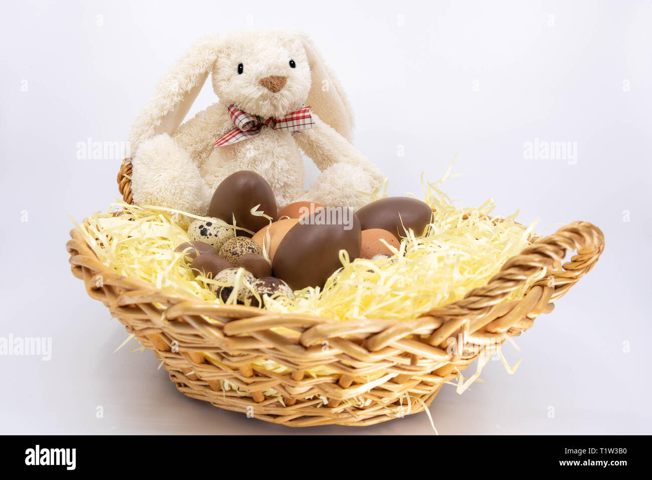 Easter bunny in a wicker basket filled with Easter eggs Stock Photo - Alamy