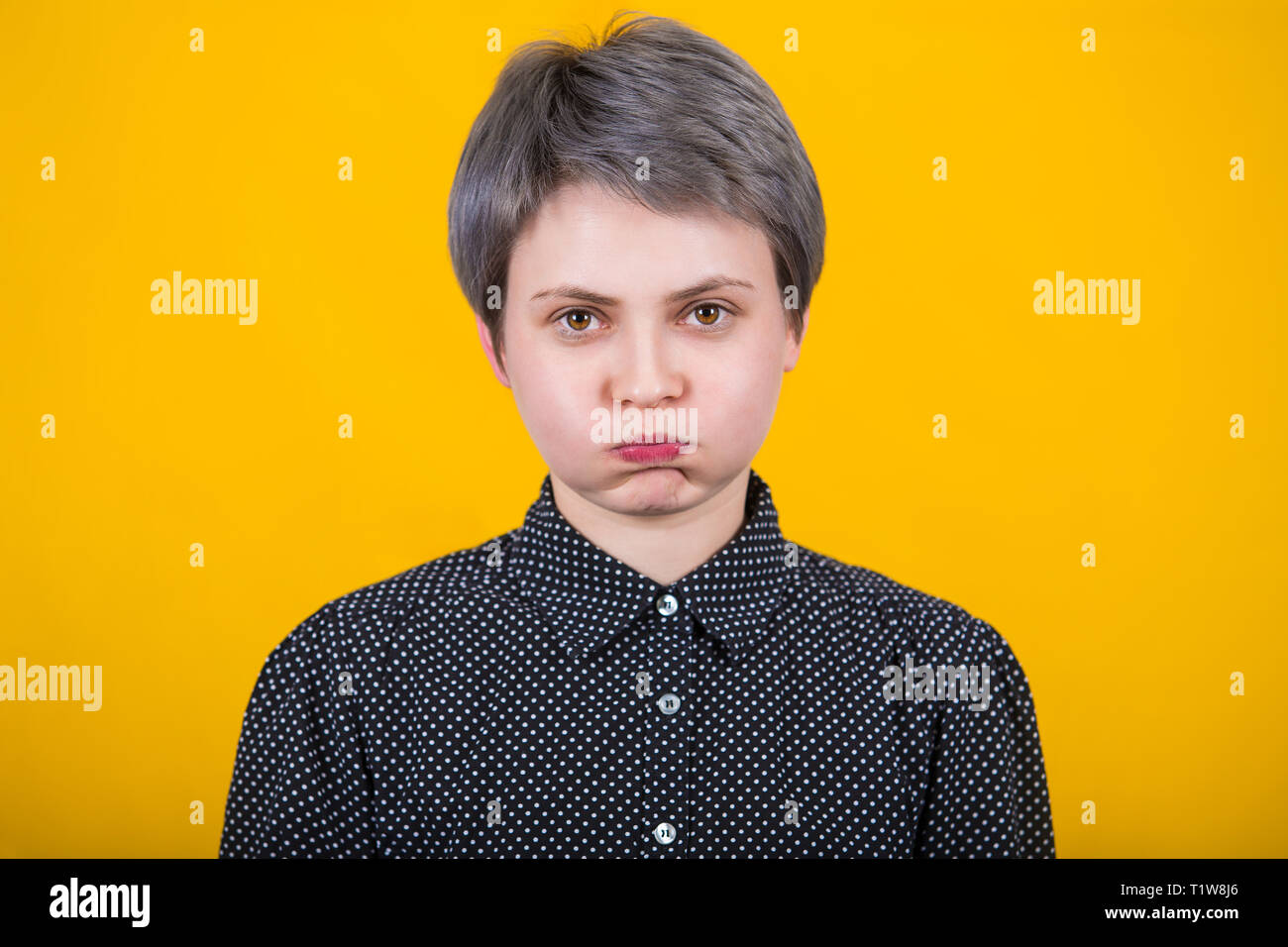 Annoyed irritated young female hipster blowing her cheeks, frowning, feeling tired or frustrated with something. Human facial expressions, emotions an Stock Photo