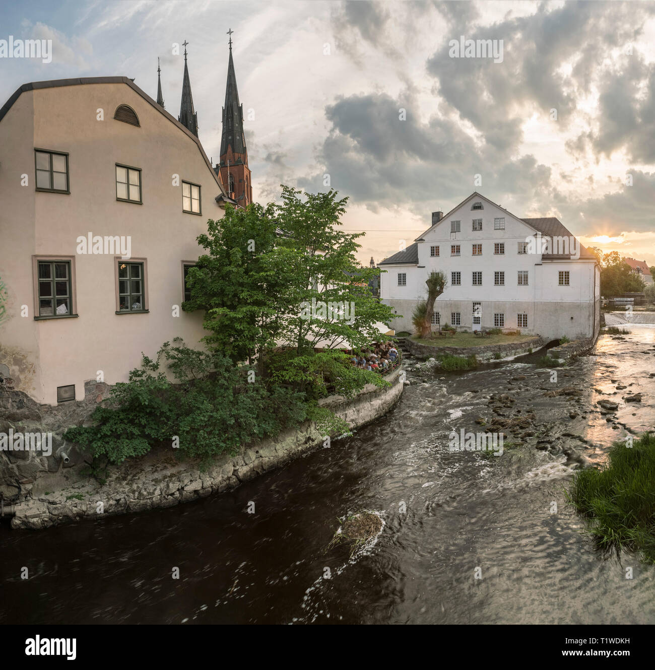 Old mill at Kvarnfallet in the Fyris river with the Cathedral (Domkyrkan) in the background at sunset. Uppsala, Sweden, Scandinavia Stock Photo